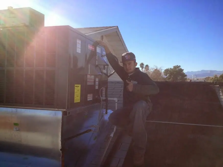 HVAC technician performing Heat Pump Repair on a rooftop unit in Lake of the Woods
